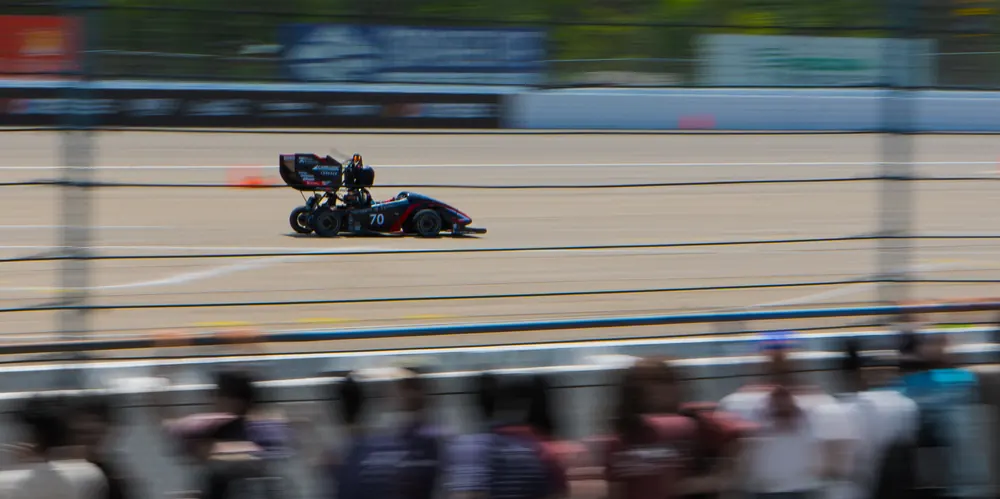 The car at speed past the grandstand, background blurred